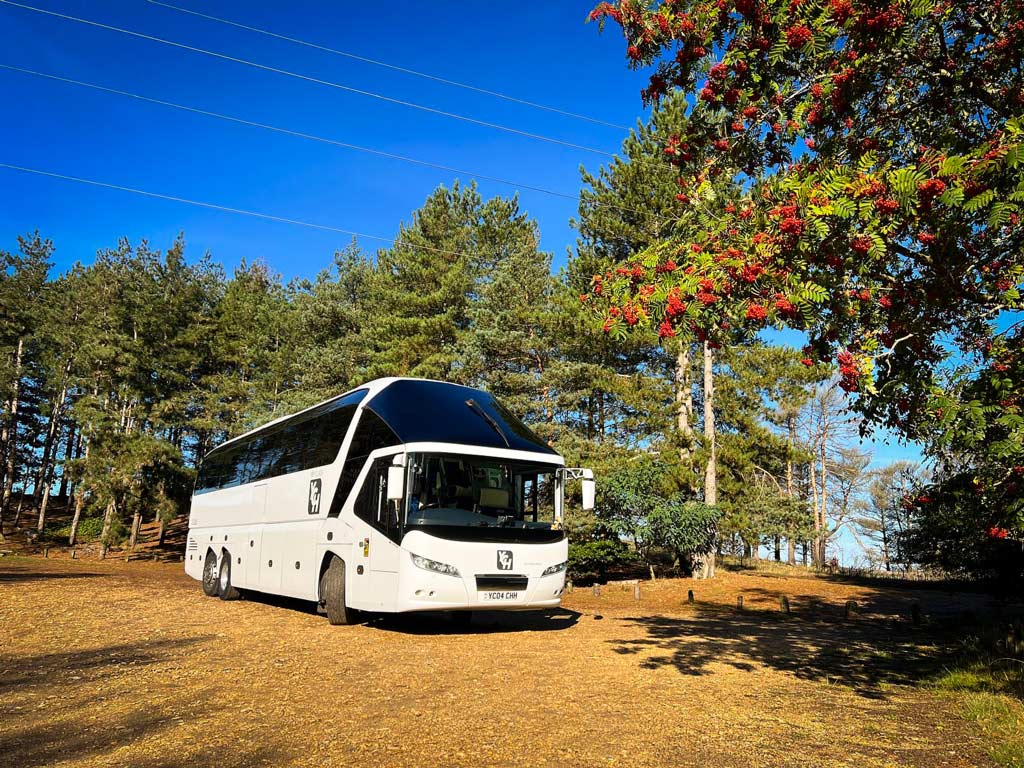 Your Coach Hire coach parked in car park of pine forest